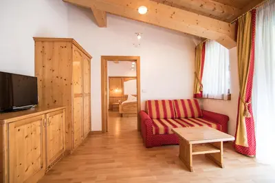 a living room with a red couch and a tv at Hotel Jager Hans in San Martino