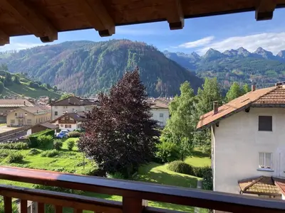a view from a balcony of a village with mountains at Appartamento Mazzini in Predazzo