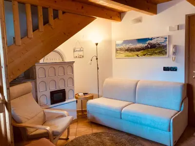 a living room with a couch and two chairs at Appartamento Mazzini in Predazzo