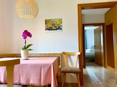 a table with a vase of purple flowers on it at Appartement Hortensia - Haus Midi in Marlengo