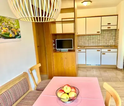 a kitchen with a table with a bowl of fruit on it at Appartement Hortensia - Haus Midi in Marlengo
