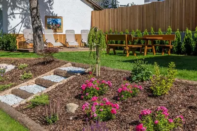 a garden with a bench and flowers in the yard at Appartement Garden in Valdaora