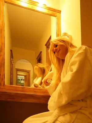 a woman sitting in front of a bathroom mirror at Appartement Garden in Valdaora