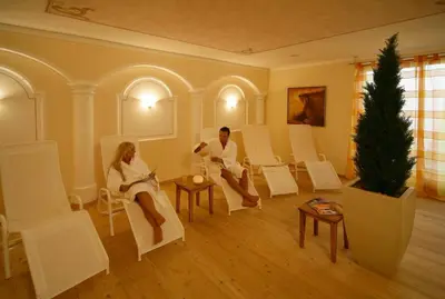 a man and woman sitting in chairs in a room at Appartement Garden in Valdaora