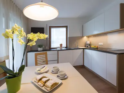 a kitchen with a table with a plate of food on it at Appartement Garden in Valdaora