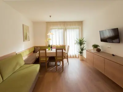 a living room with a table and chairs and a couch at Appartement Garden in Valdaora