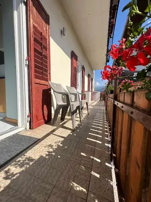 a row of chairs sitting on a sidewalk next to a building at Pippi Home in Castello di Fiemme