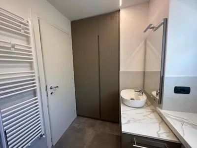 a bathroom with a sink and a mirror and a toilet at Pippi Home in Castello di Fiemme