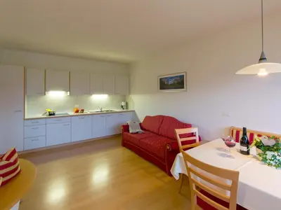 a living room with a red couch and a table at Appartements Steiner in Valdaora