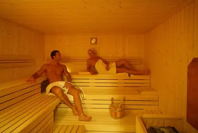 a man and woman sitting in a sauna at Appartements Steiner in Valdaora