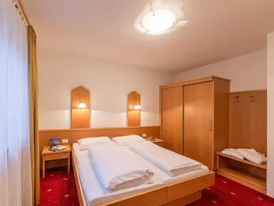 a bedroom with a large white bed with wooden cabinets at Appartements Steiner in Valdaora