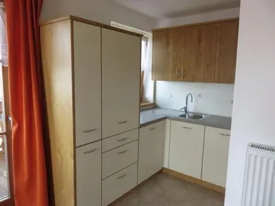 a small kitchen with white cabinets and a sink at Parleitnerhof Ferienwohnung Abendrot in Mühlbach