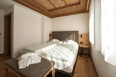 a bedroom with a bed and a table with towels on it at Aparthotel Zum Schlössl in Villa Ottone
