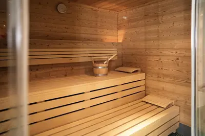 a wooden sauna with a bucket in it at Aparthotel Zum Schlössl in Villa Ottone