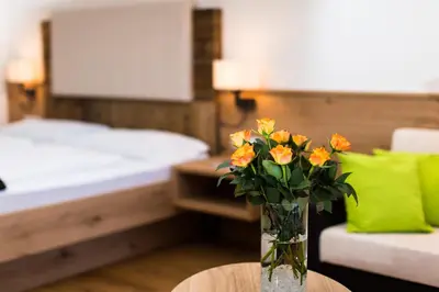 a vase of flowers sitting on a table in a room at Hotel Gasthof Kircher in Fiè