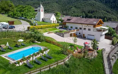 an aerial view of a house and a swimming pool at Hotel Gasthof Kircher in Fiè