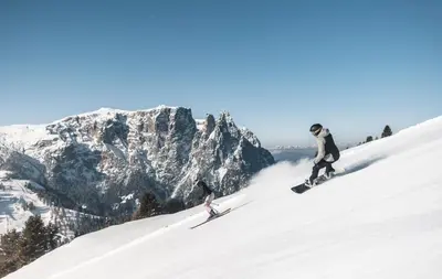 a group of people skiing down a snow covered mountain at Hotel Gasthof Kircher in Fiè