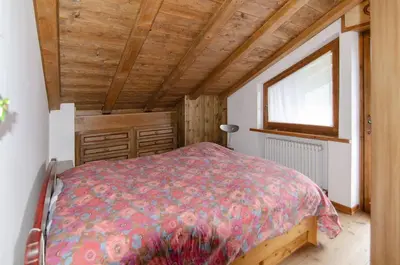 a bedroom with a bed and a window at Estate in montagna in San Vito di Cadore