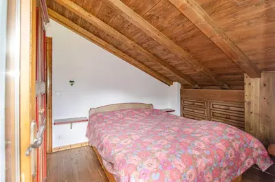 a bedroom with a bed and a wooden ceiling at Estate in montagna in San Vito di Cadore