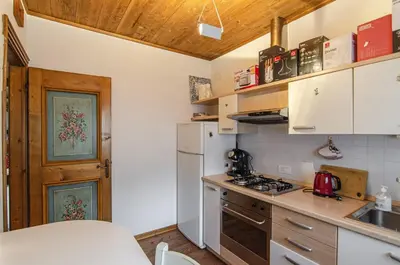 a kitchen with a white refrigerator and a stove at Estate in montagna in San Vito di Cadore