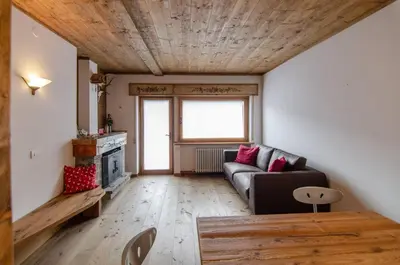a living room with a couch and a wooden ceiling at Estate in montagna in San Vito di Cadore