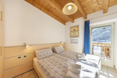 a bedroom with a bed and a window at Appartamenti Maria in Canazei