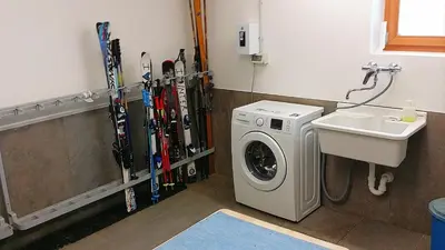 a laundry room with a washing machine and skis at Apartments Brunella in La Villa