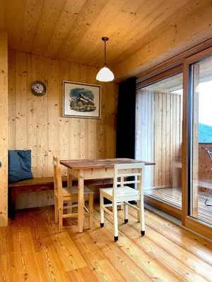 a dining room with a table and chairs and a window at Schallerhof Sterzing - Deine Auszeit mit Ausblick in unseren Ferienwohnungen auf dem Bergbauernhof in Südtirol in Vipiteno