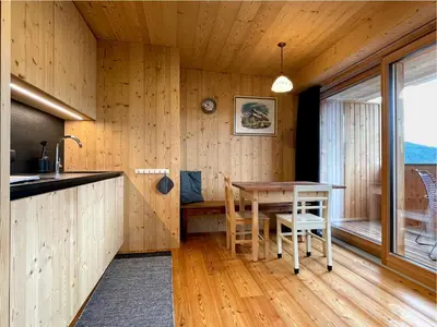 a kitchen with wooden walls and a table and chairs at Schallerhof Sterzing - Deine Auszeit mit Ausblick in unseren Ferienwohnungen auf dem Bergbauernhof in Südtirol in Vipiteno