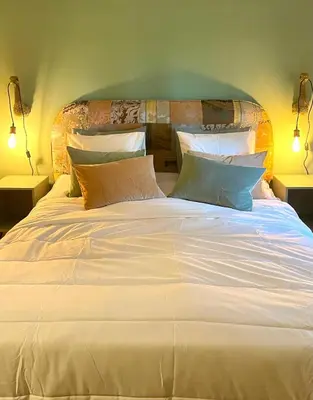 a large white bed with pillows on top of it at Brunico 20 in Brunico