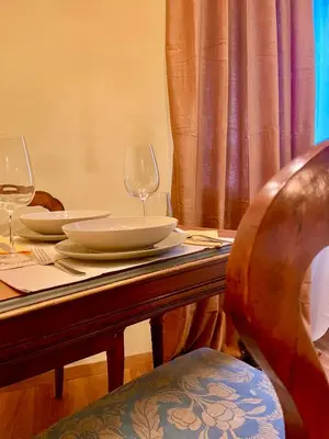 a table with two wine glasses and plates on it at Brunico 20 in Brunico