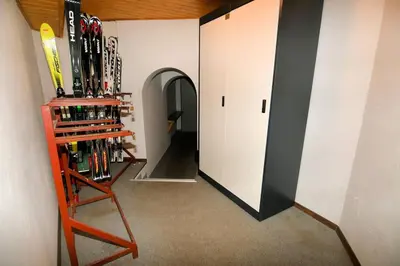 a room with a bunch of skis on a wall at Appartamento dles Dolomites in Corvara in Badia