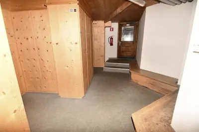 an empty room with wooden walls and a hallway at Appartamento dles Dolomites in Corvara in Badia