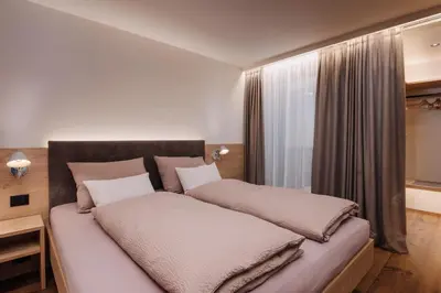 a bedroom with a bed with two pillows on it at Max Green Wood Apartments in Siusi