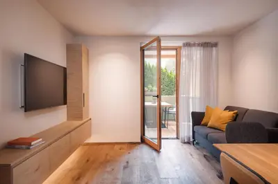 a living room with a tv and a couch at Max Green Wood Apartments in Siusi