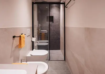 a bathroom with two toilets and a shower at Max Green Wood Apartments in Siusi