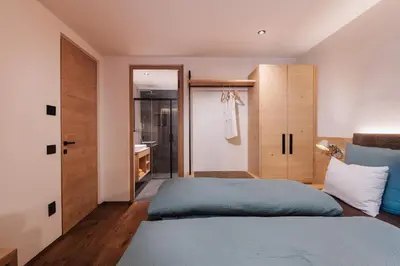 a bedroom with a bed and a bathroom at Max Green Wood Apartments in Siusi