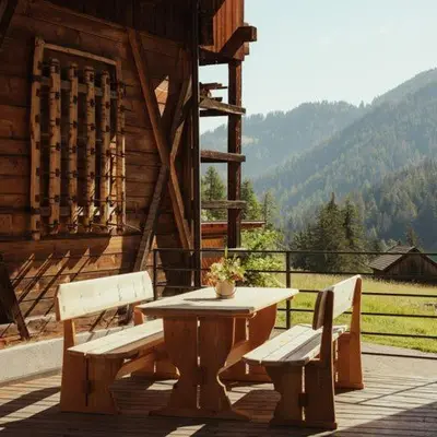 a table and two benches on a porch of a cabin at Ostí Vedl in San Martino in Badia