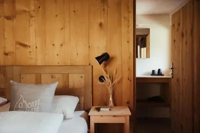 a bedroom with a bed and a table with a lamp at Ostí Vedl in San Martino in Badia
