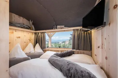 a room with two beds and a flat screen tv at Mountain Caravan - Zirben Nestl in Nova Ponente