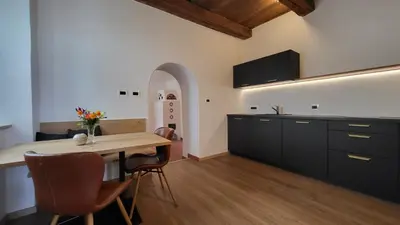 a kitchen with a wooden table and a dining room at Fruemess - Historic Refugium in Parcines