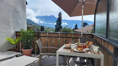 a table with a plate of food on a balcony at Fruemess - Historic Refugium in Parcines