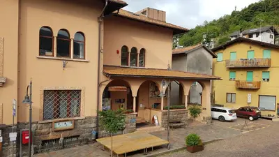a building with a wooden table in front of it at Casa MARGHERITA in Grumes