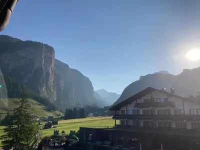 a building in a valley with mountains in the background at Week End Senoner in Selva di Val Gardena