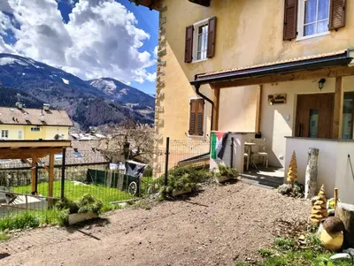 a building sitting on top of a stone wall at Camera con bagno privato in Tesero