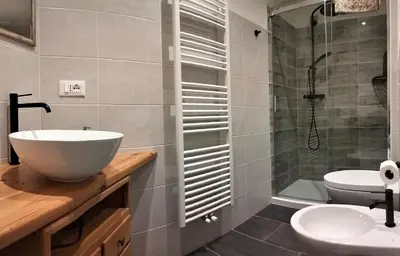 a bathroom with a sink and a toilet and a tub at Camera con bagno privato in Tesero
