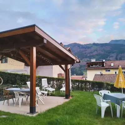 a gravel road next to a house with a fence at Camera con bagno privato in Tesero