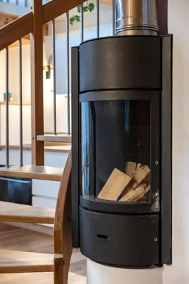 a fireplace with wood in it next to a staircase at KARINA Mulino in Montagna