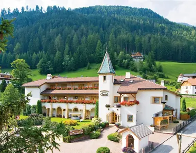 a large white building with a tower on top of it at Residence Ciastel in Ortisei