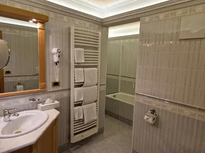 a bathroom with a sink and a mirror and a tub at Residence Ciastel in Ortisei